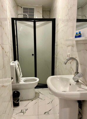 A bathroom with a toilet, bidet, sink, and a shower enclosure. - Taksim Heli Suites (Istanbul)