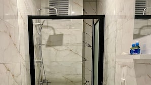 A bathroom with a toilet, a sink, and a shower area. - Taksim Heli Suites (Istanbul)