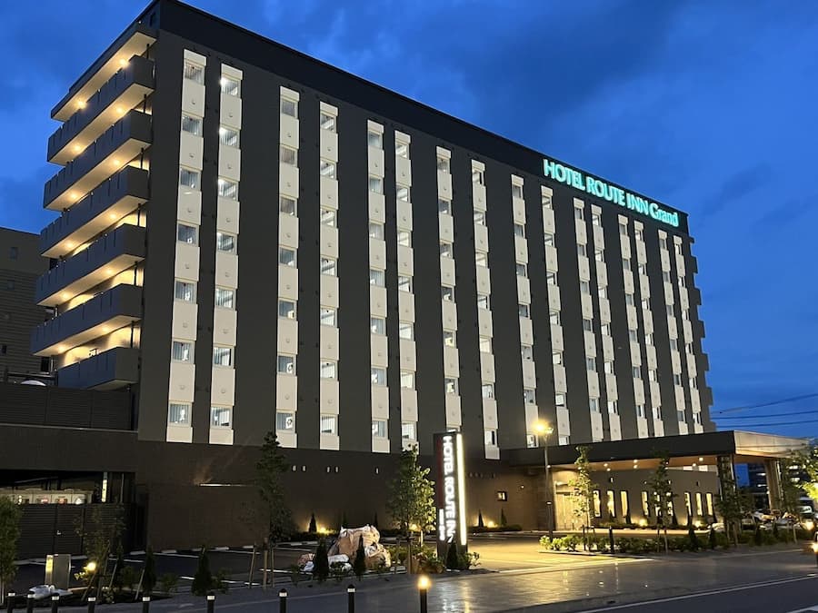 Un hotel de varios pisos con un letrero destacado que dice 'HOTEL ROUTE INN Grand'.