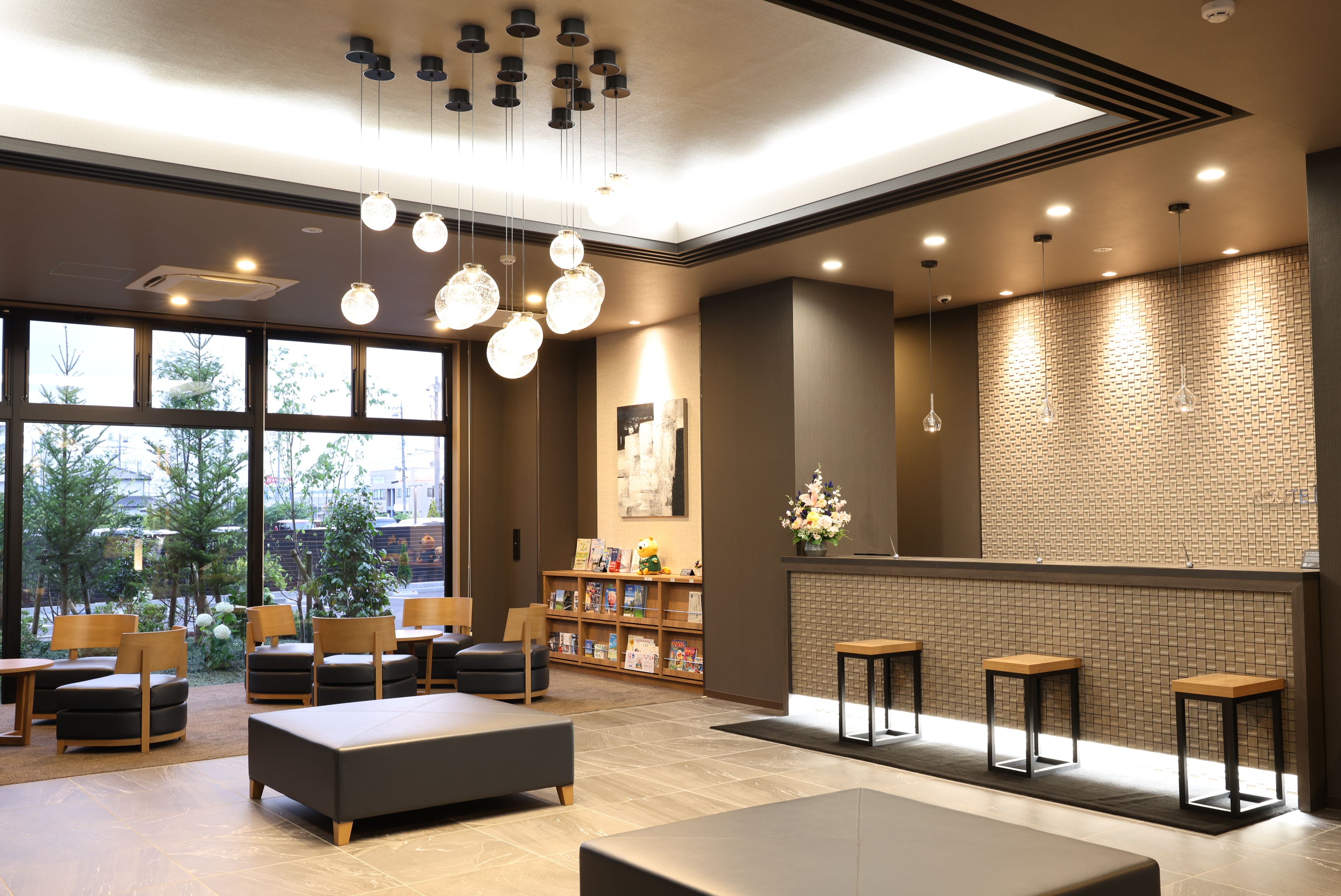 A modern lobby with seating, a fireplace, and a view of the outdoors.