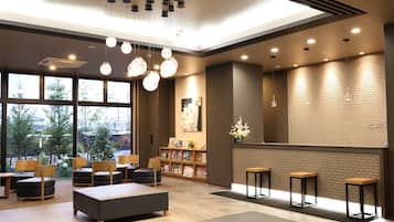 A modern lobby with seating, a fireplace, and a view of the outdoors.