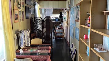 A room with a dining table, chairs, a bookshelf, and a decorative partition.
