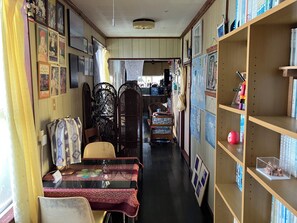 A room with a dining table, chairs, a bookshelf, and a decorative partition. - Casa de hamaca (Miyakojima)