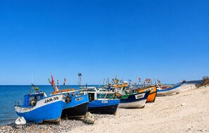 Boote mit Kennzeichen auf einem Kiesstrand.