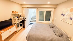 Quarto com cama, escrivaninha, cadeira, guarda-roupa, janela e escada para área externa.
