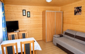 A wooden-paneled room with a television, a sofa, a table, and a cabinet. - Gorgeous home in Jaroslawiec with swimming pool (Jaroslawiec)
