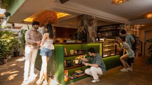 A bar area with a green counter, books, and a chessboard. - Zen Colive (Pune)