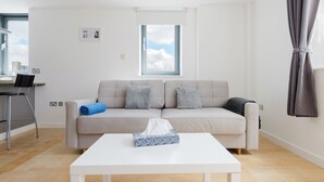 Uma sala de estar moderna com sofá, mesa de centro e janela.