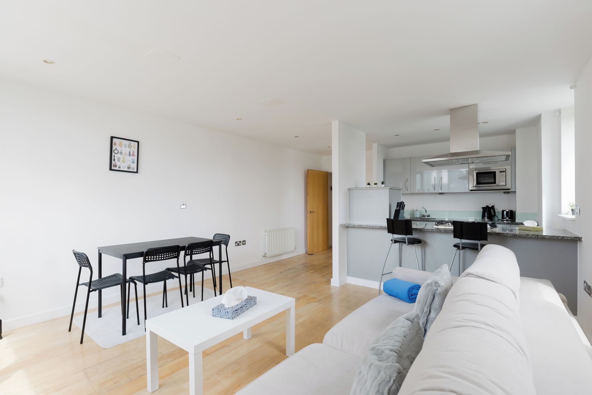 A modern apartment with a dining area, kitchen, and living room.