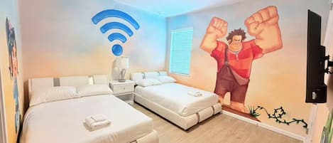 A hotel room with two beds, a nightstand, a lamp, a wall-mounted TV, and a Wi-Fi symbol.