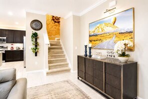 A modern living room with a staircase, a dining area, and a kitchen. - 27BR Grand Luxury Villas  Two Side-by-Side Homes Near Disney (Kissimmee)