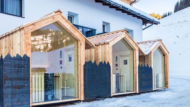 A modern chalet with wooden gable-end rooms, a sloped roof, and a snowy landscape. - Ski-in, ski-out in Alpine style and sauna (Hinterglemm)