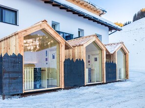 Een moderne chalet met houten dakramen, een schuin dak en een besneeerd landschap.