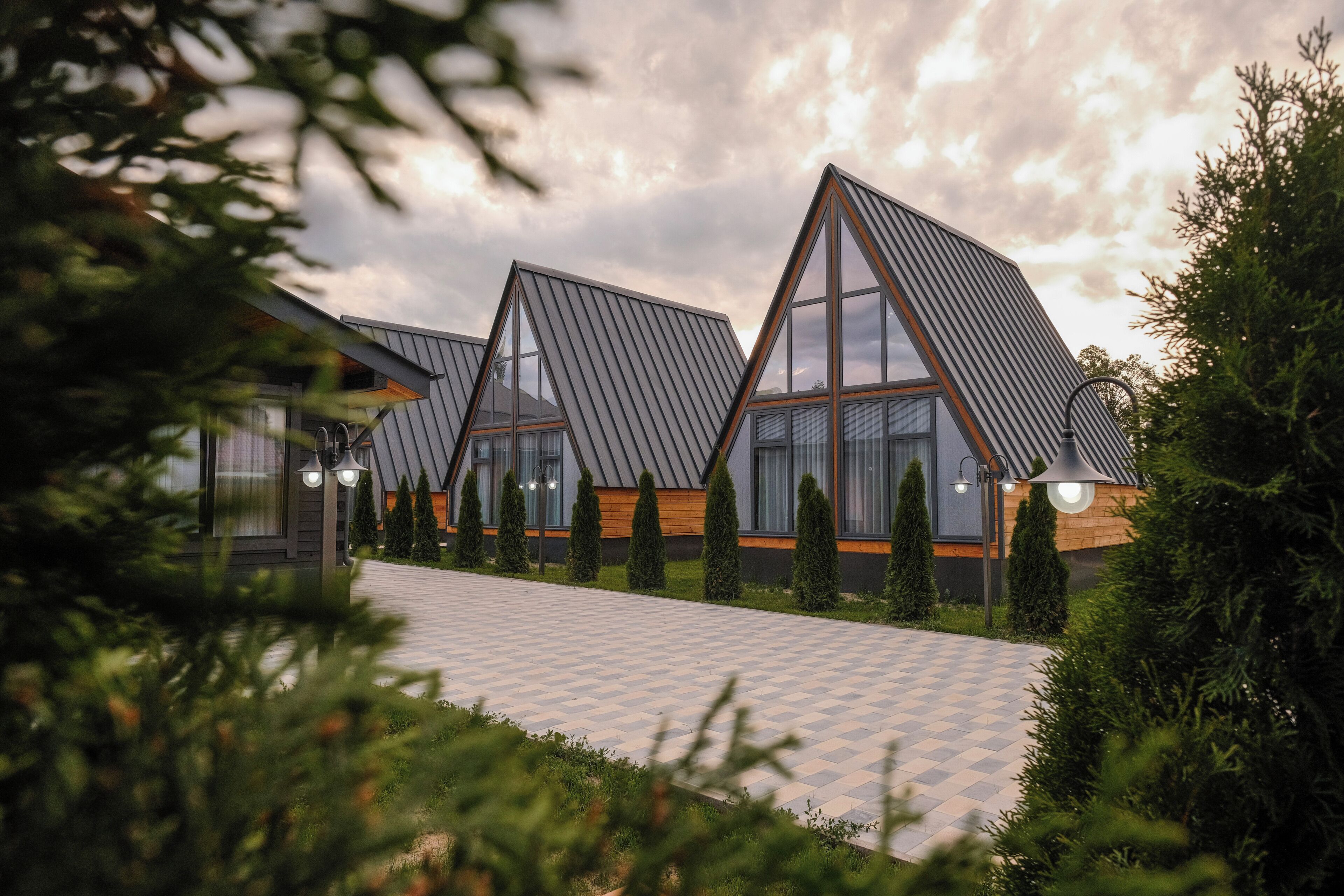 A modern building with triangular roofs and a paved walkway.