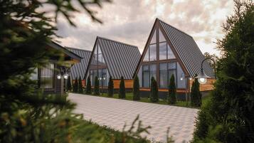 A modern building with triangular roofs and a paved walkway.