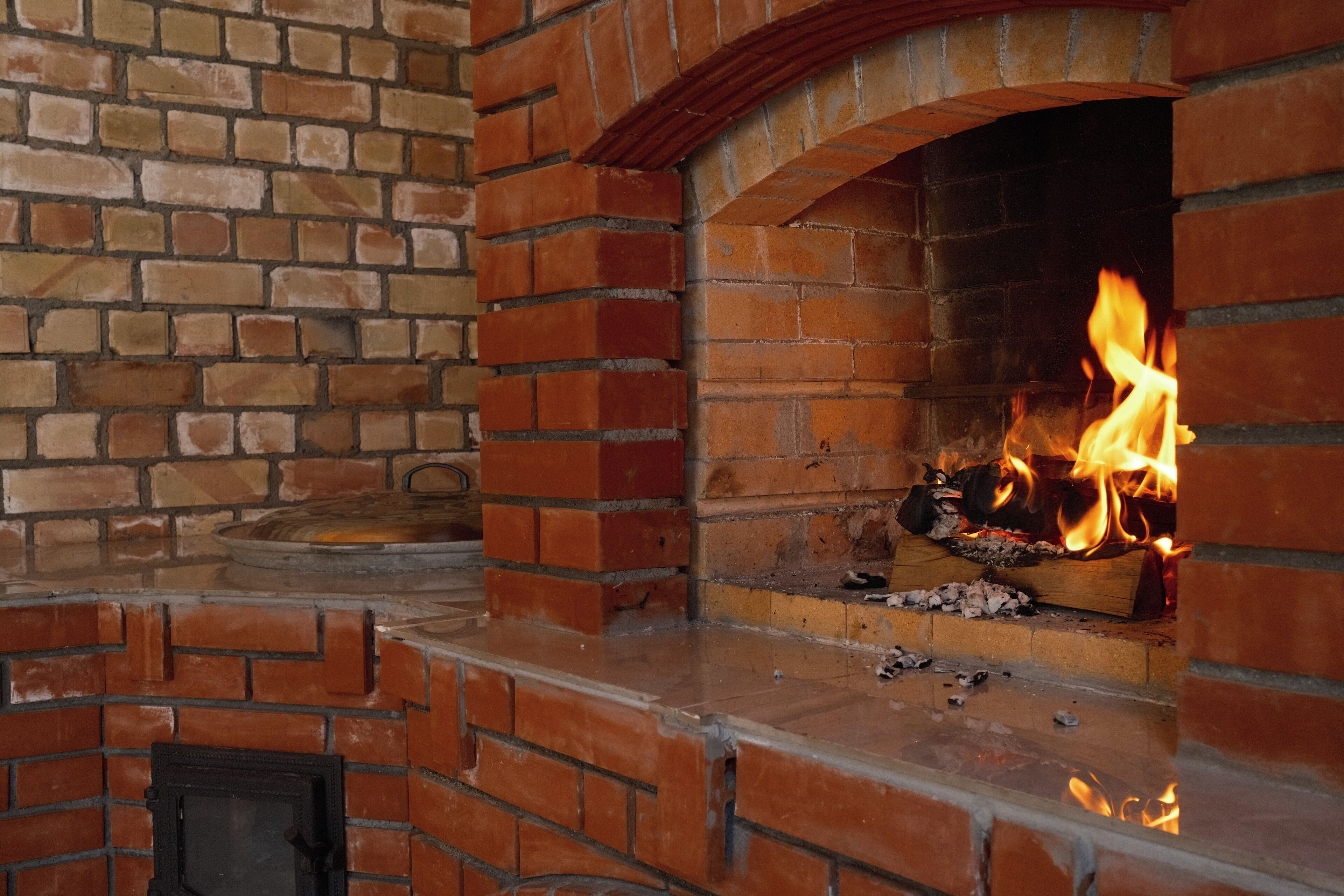 A brick fireplace with a fire burning inside.