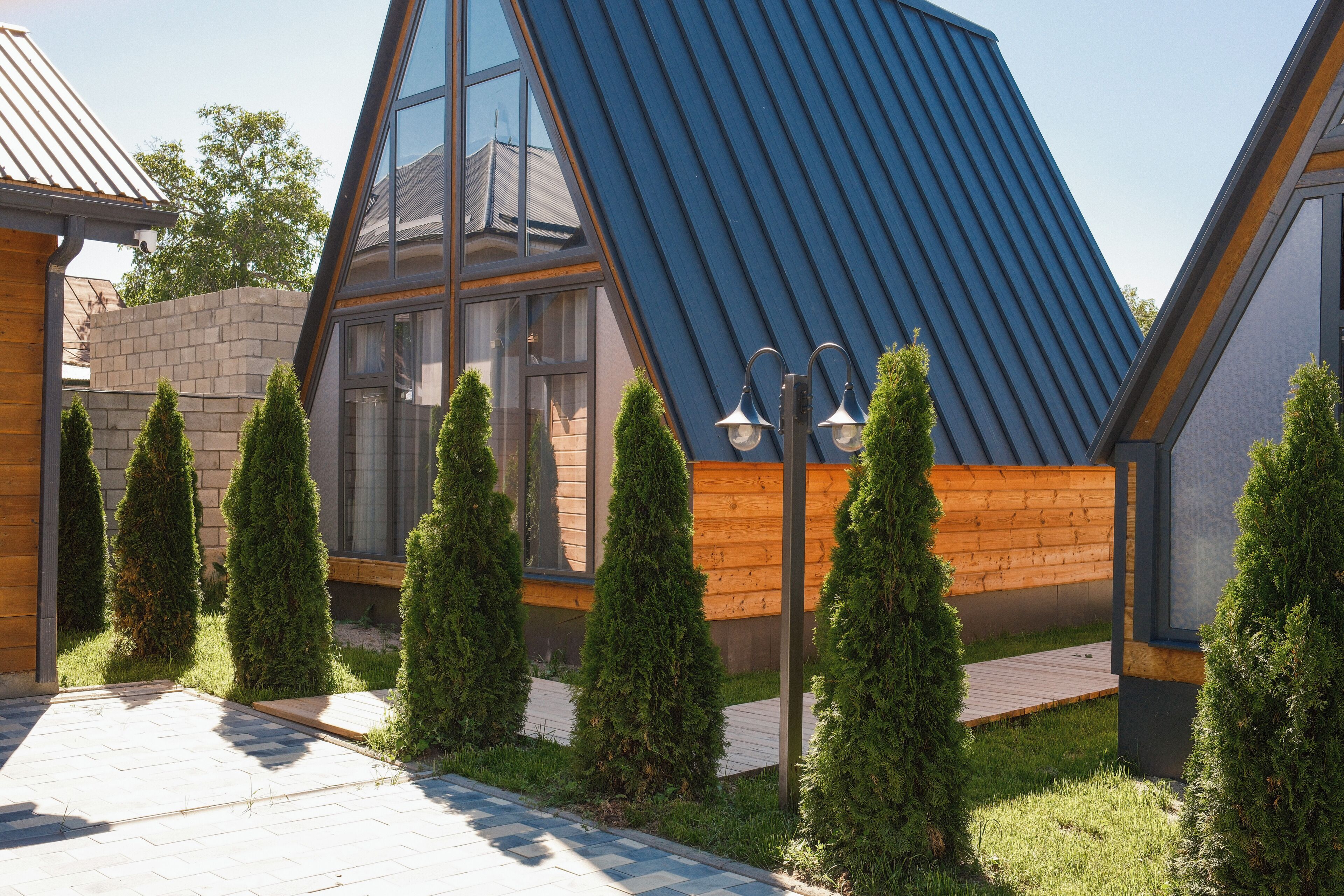 A modern house with a sloped roof, wooden siding, and a paved driveway.
