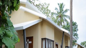 A row of single-story buildings with a flat roof, large windows, and a paved walkway.