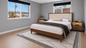 A bedroom with a large bed, two bedside tables, a nightstand, a window, and a view of the outside. - 1,100 sf Spacious Cozy 2BR Near Denver DT, Red Rocks, and Rockies! (Arvada)