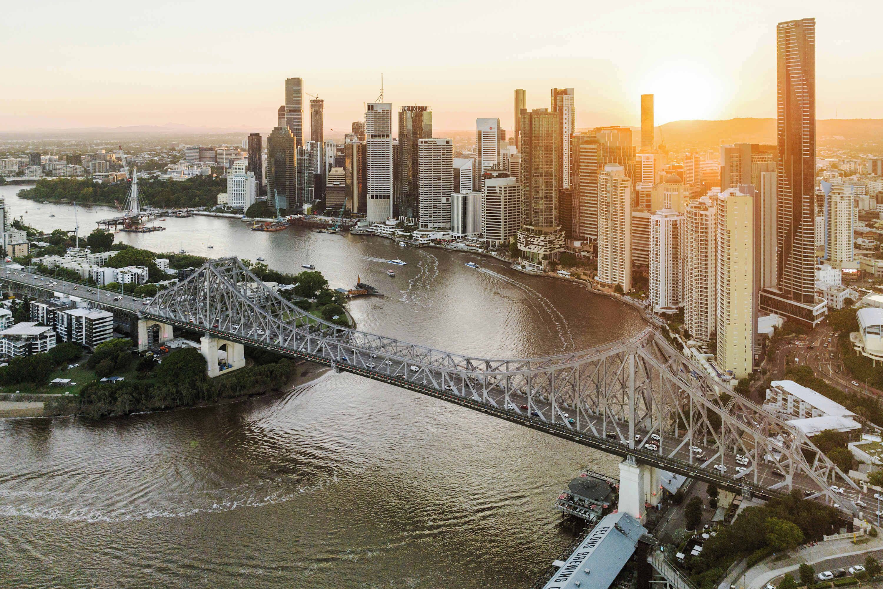 A cityscape with a prominent bridge, high-rise buildings, and a river.