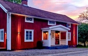 A red two-story house with a white porch and a chimney. - 2 bedroom lovely home in Lönashult (Lönashult)