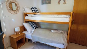 A bunk bed room with a bedside table, lamp, and a small rug. - Via Radiras - Laax | Flims | Lake Cauma | Hiking (Laax)