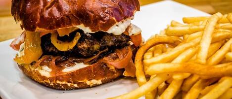 A burger with fries on a white plate.