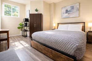 A bedroom with a bed, a desk, a wardrobe, and a window. - Studio 1 - Comfortable Guest Studio by Cedars-Sinai, Beverly Center (Beverly Hills)