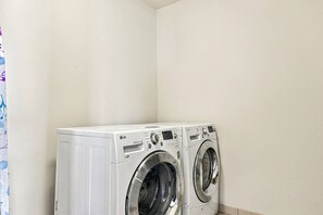 A laundry room with two front-loading washing machines. - Stylish High-Rise Loft in Downtown Detroit, City Views (Detroit)