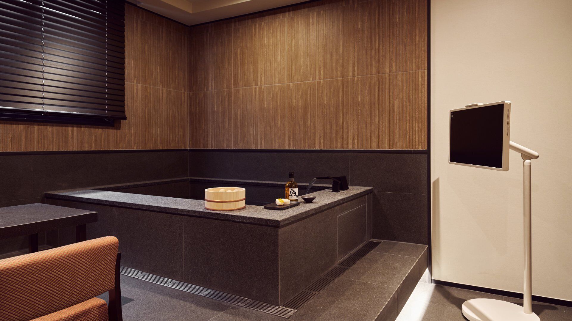 Un baño moderno con una bañera grande, un tocador de madera y un inodoro.