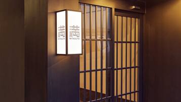 A traditional Japanese gate with a lit sign above it.