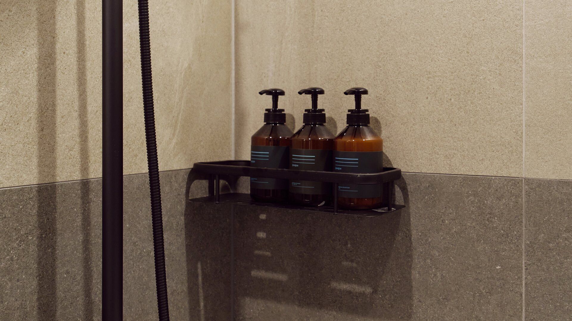 A bathroom with a black soap dispenser holder containing three bottles.