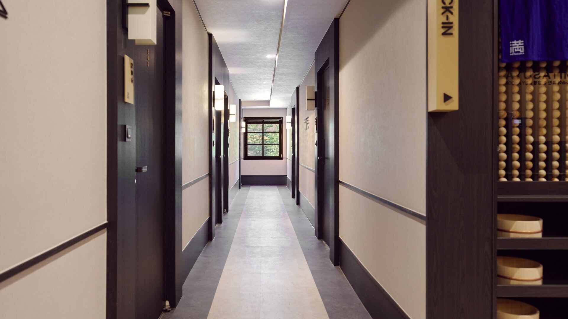 A hotel corridor with doors, a window, and a vending machine.