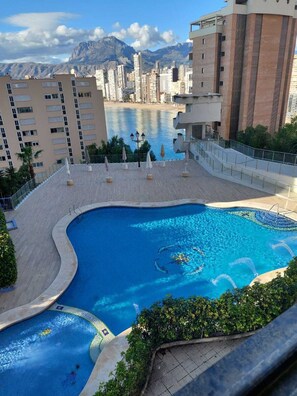 Une piscine offrant une vue sur le paysage urbain et les montagnes en arrière-plan.