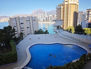 A rooftop swimming pool with a view of the sea and mountains, surrounded by buildings. - Modern Pool&Sea View Apartment Benidorm (Benidorm)