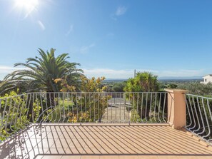A balcony with a metal railing, a tiled floor, and a view of a distant landscape. - Mestral by Interhome (Palau Savardera)