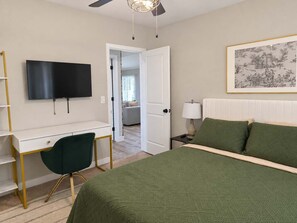 A bedroom with a bed, a desk, a chair, a television, and a painting on the wall. - Chandler 4BR | Private Pool | Pet Friendly (Chandler)