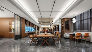 A modern hotel lobby with a marble floor, a central dining table, and seating arrangements. - UrCove Yangzhou China Grand Canal Museum (Yangzhou)