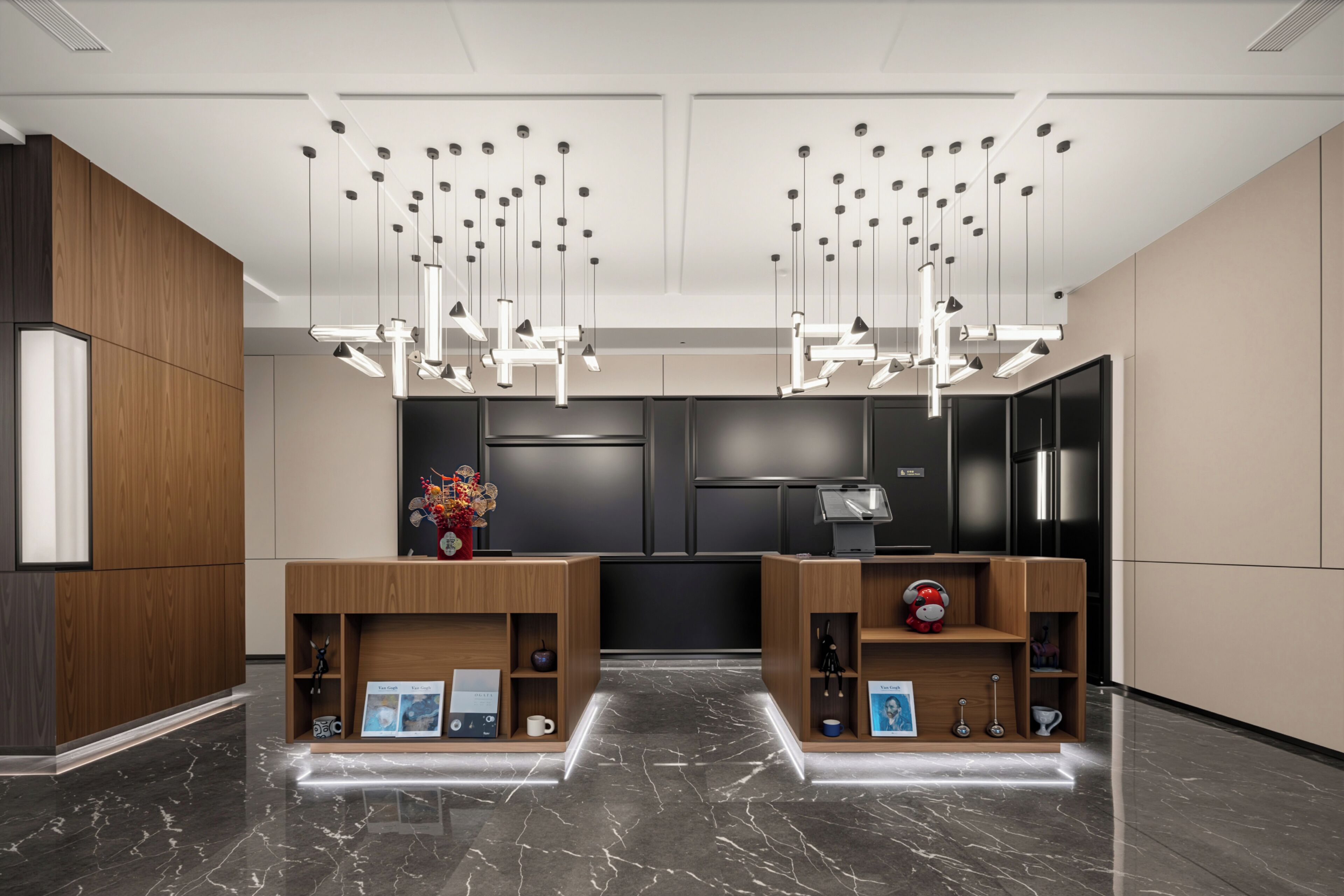 Una moderna zona de recepción con mostradores de madera, un mostrador negro y un techo con luces colgantes.
