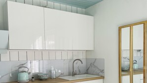 A modern kitchen with white cabinetry, a wooden countertop, a marble backsplash, and a built-in oven. - A "nice" house (Le Château-d'Oléron)