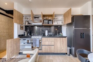 Eine moderne Küche mit Holzschränken, einem Herd und einem Kühlschrank.