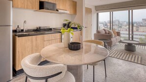 Eine moderne Küche mit Holzausstattung, einer Mikrowelle und einem Essbereich mit rundem Tisch und Stühlen.