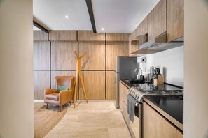 Eine moderne Küche mit Holzausstattung, einem Gasherd und einem eingebauten Backofen.
