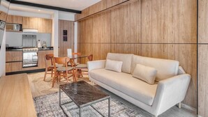 Un salon moderne avec un canapé, une table basse et un coin repas.