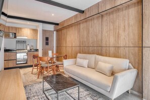 Ein modernes Wohnzimmer mit Sofa, Couchtisch und Essbereich.