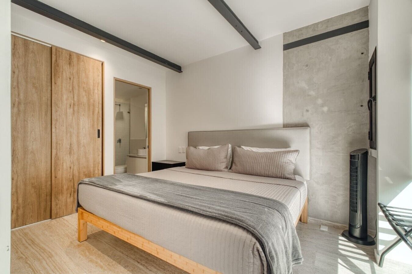 A bedroom with a bed, a wardrobe, a shower, and a heater.