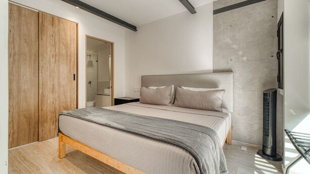 Ein Schlafzimmer mit Bett, Kleiderschrank, Dusche und Heizung.