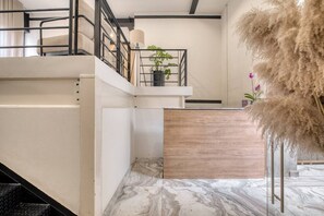 Ein modernes Interieur mit Treppe, Pflanze und einer dekorativen Pflanzenkomposition.