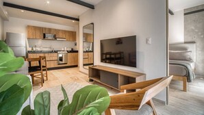 Eine moderne Küche mit Holzausbau, integriertem Backofen und großem Flachbildfernseher an der Wand.
