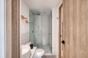 A modern bathroom with a glass shower enclosure, a white sink, and a toilet. - Myla - Casa Calderon - Roma Norte (HF) (Mexico City)